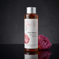 Bottle of 'Rose Beauty' bath and body oil with a pink flower on a dark background- The Australian Olive Oil Soap