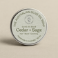 Olive oil balm container labeled 'Cedar + Sage' from The Australian Olive Oil Soap on a beige background