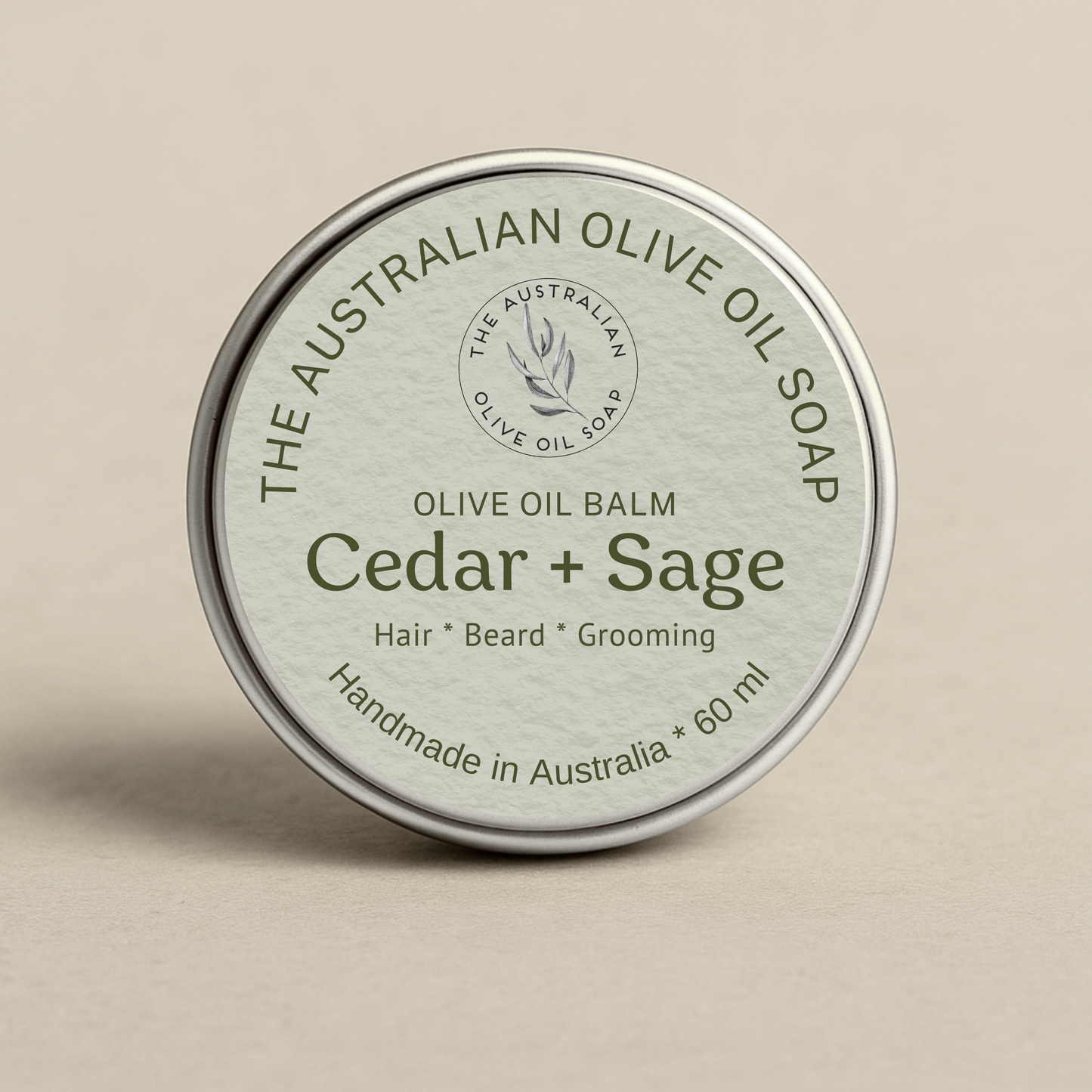 Olive oil balm container labeled 'Cedar + Sage' from The Australian Olive Oil Soap on a beige background