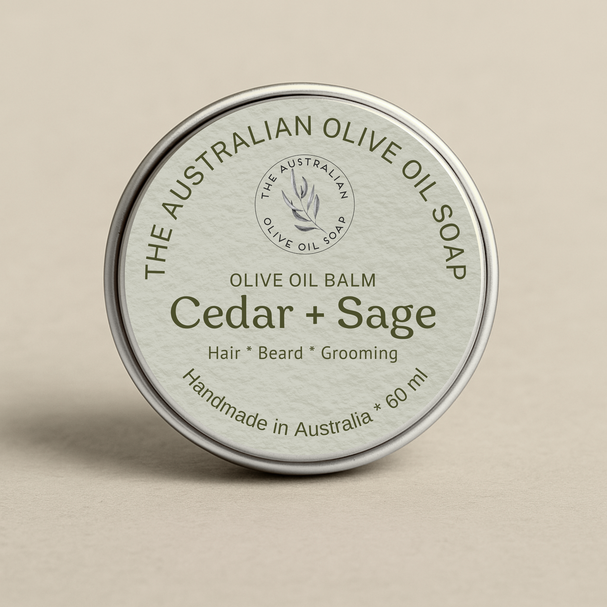 Olive oil balm container labeled 'Cedar + Sage' from The Australian Olive Oil Soap on a beige background
